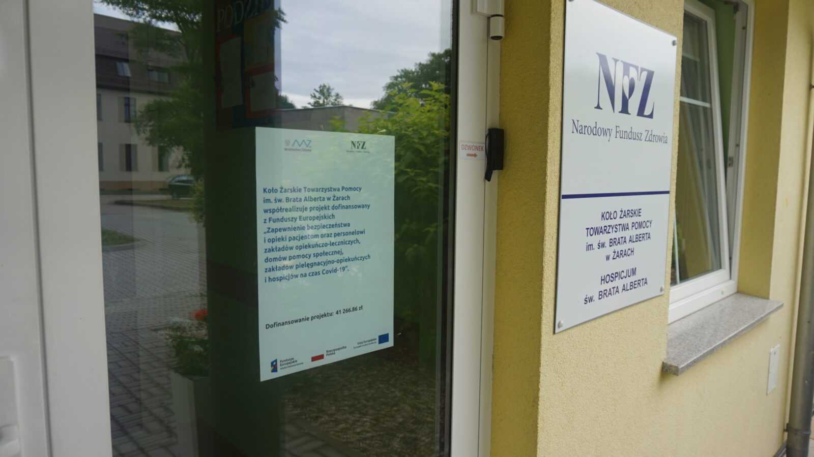 drzwi wejciowe budynku oraz plakatr z dofinansowaniem